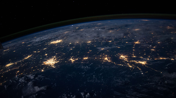 View of Earth from space showing illuminated cities at night.
