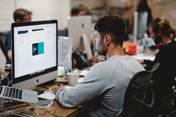 Man working on a computer in a modern office environment.